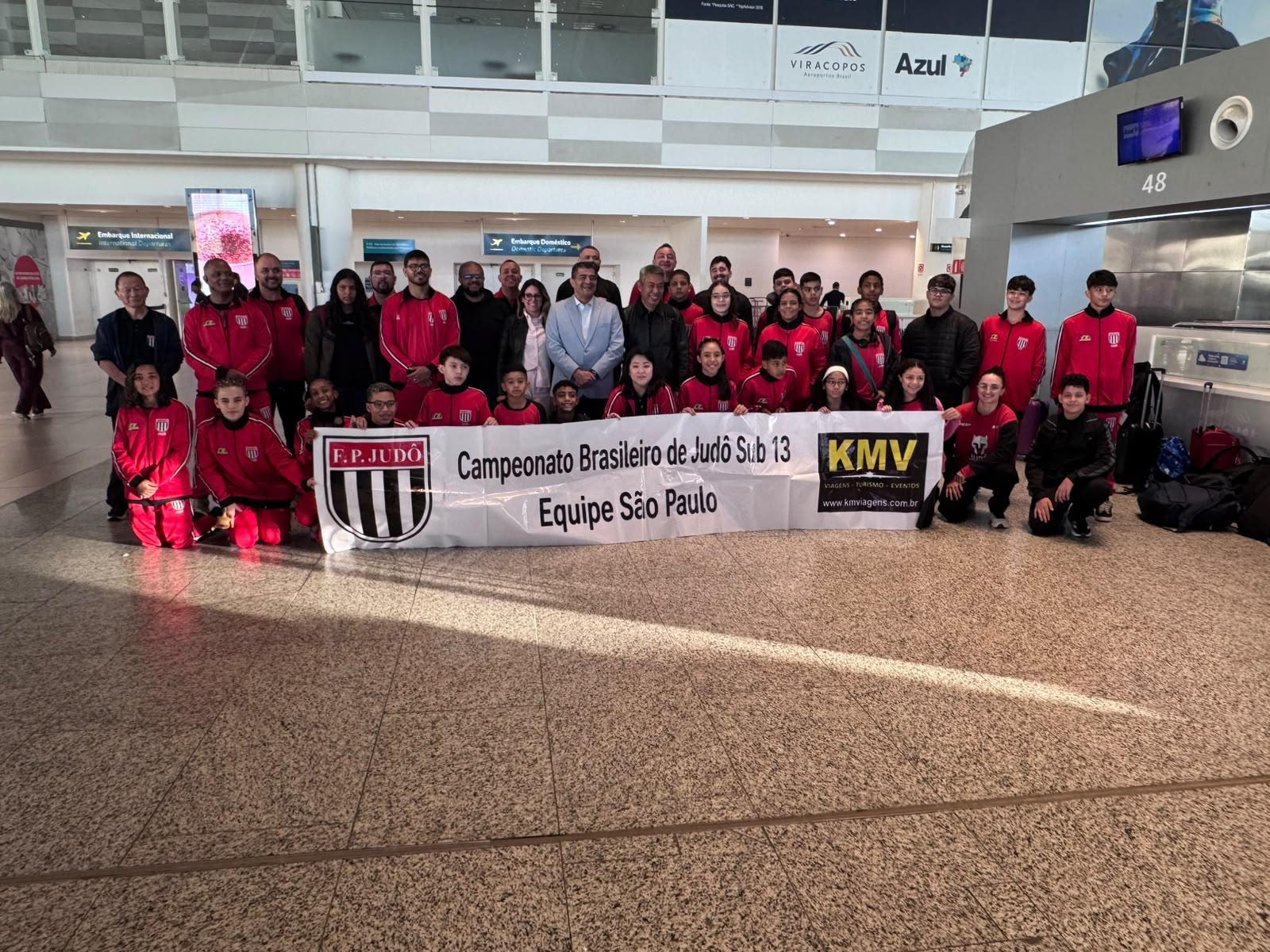 Delegação da Federação Paulista de Judô reunida com a faixa do Campeonato Brasileiro de Judô Sub-13 no embarque em Viracopos