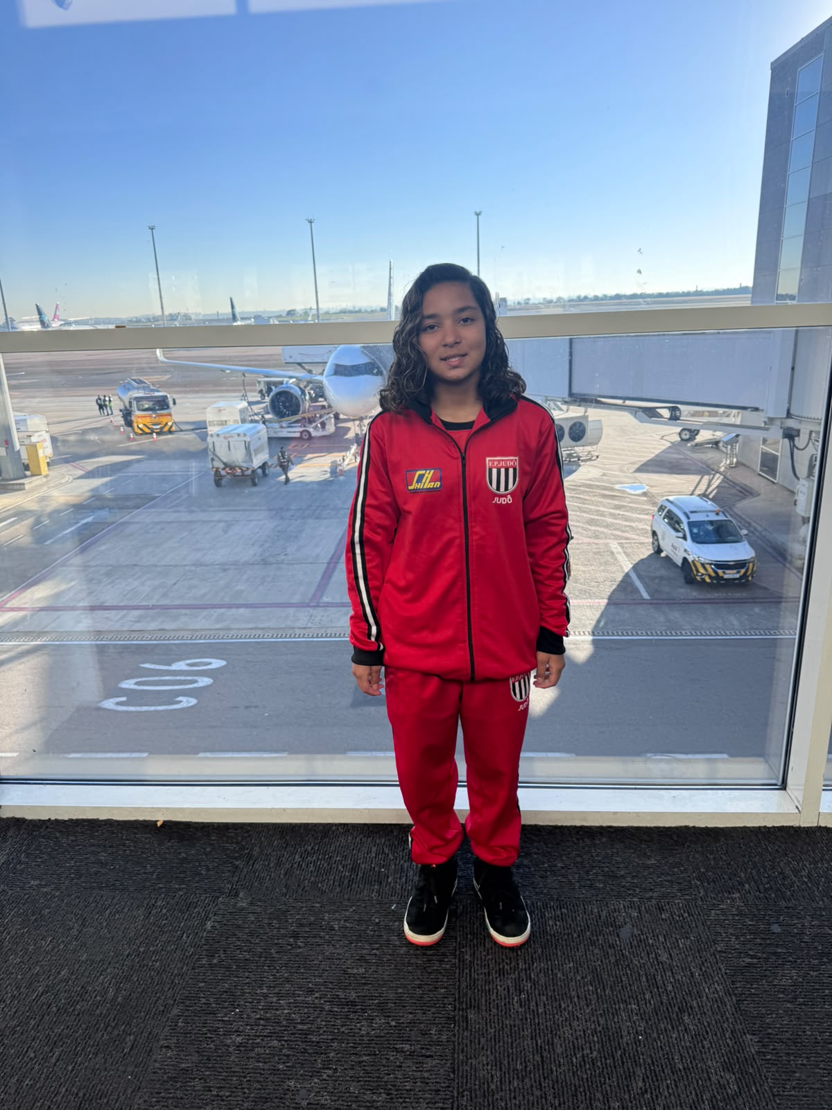 Lídia Sayuri Tsuji Palma com o agasalho oficial da seleção paulista de judô na sala de embarque