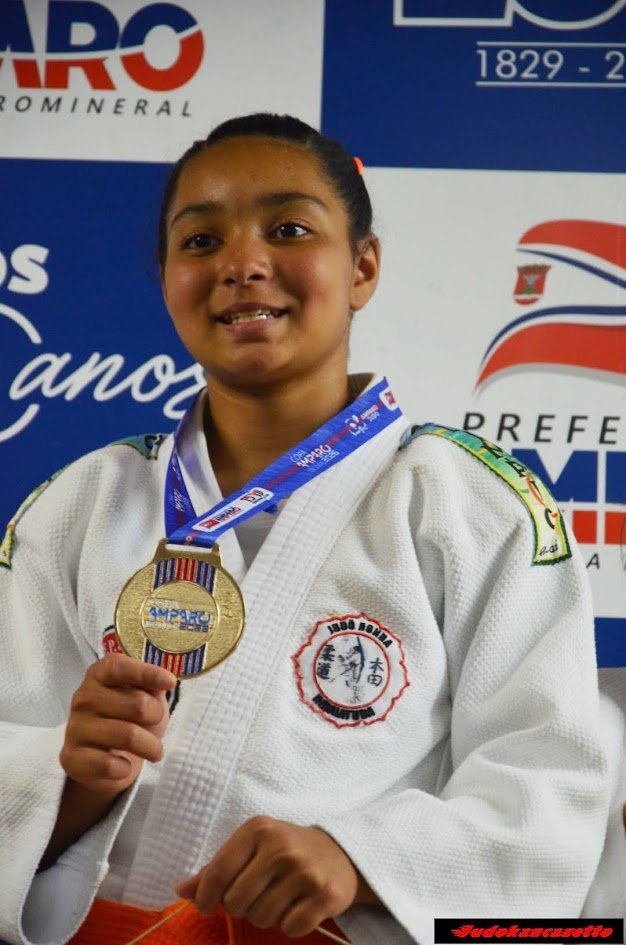 Lídia Sayuri sorrindo com a medalha de ouro da Copa Amparo 2026 no peito