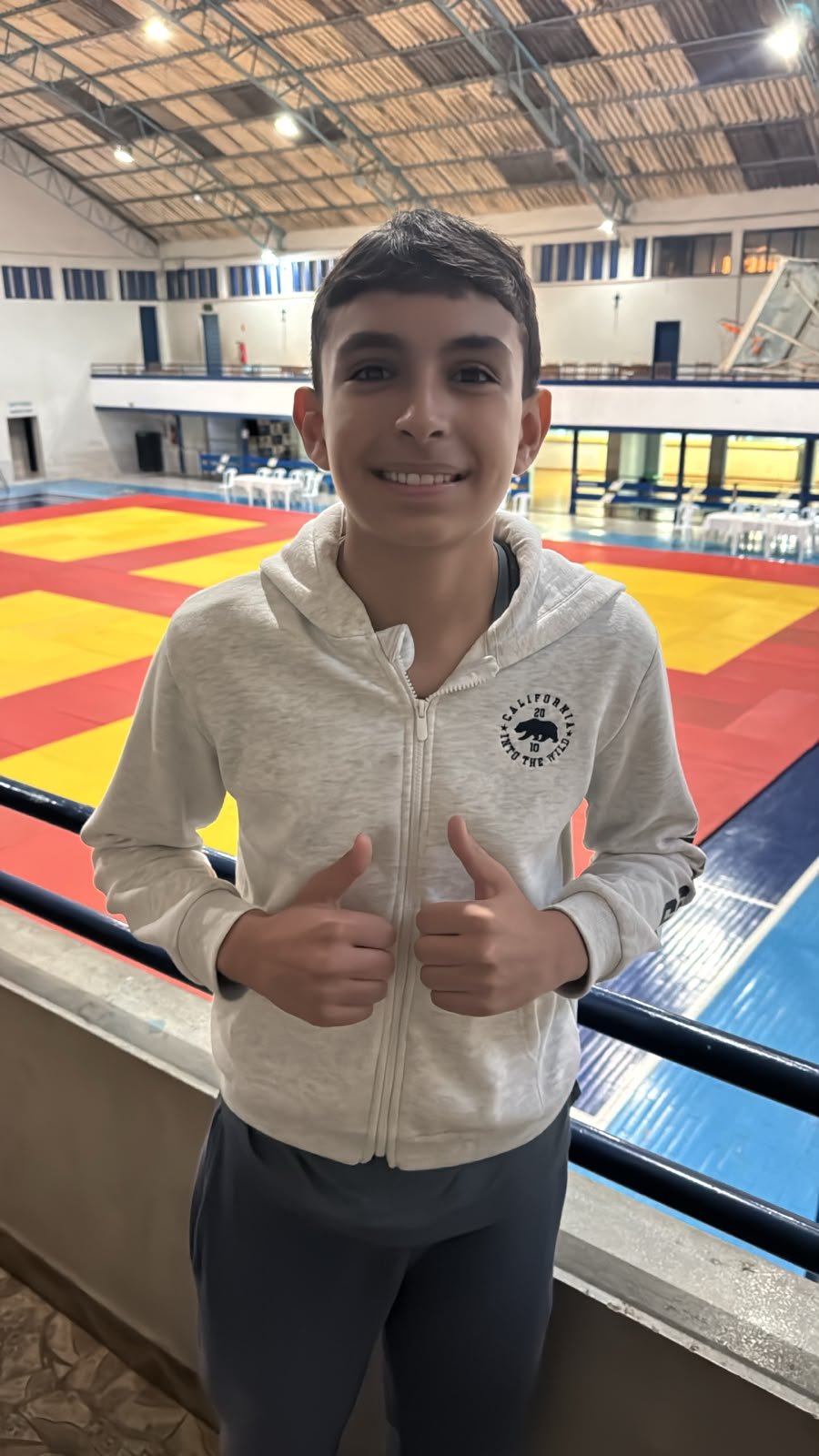 Luis Antonio sorrindo com os polegares pra cima na arquibancada da Copa Amparo 2026