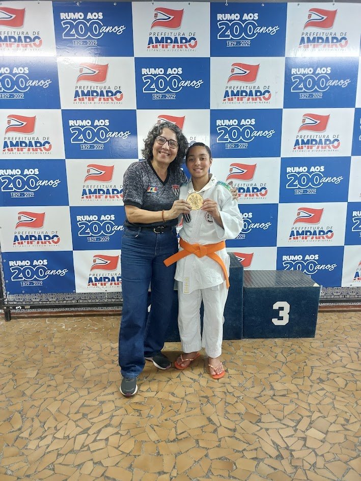 Sensei Rosana ao lado da Lídia Sayuri, segurando a medalha de campeã brasileira Sub-13