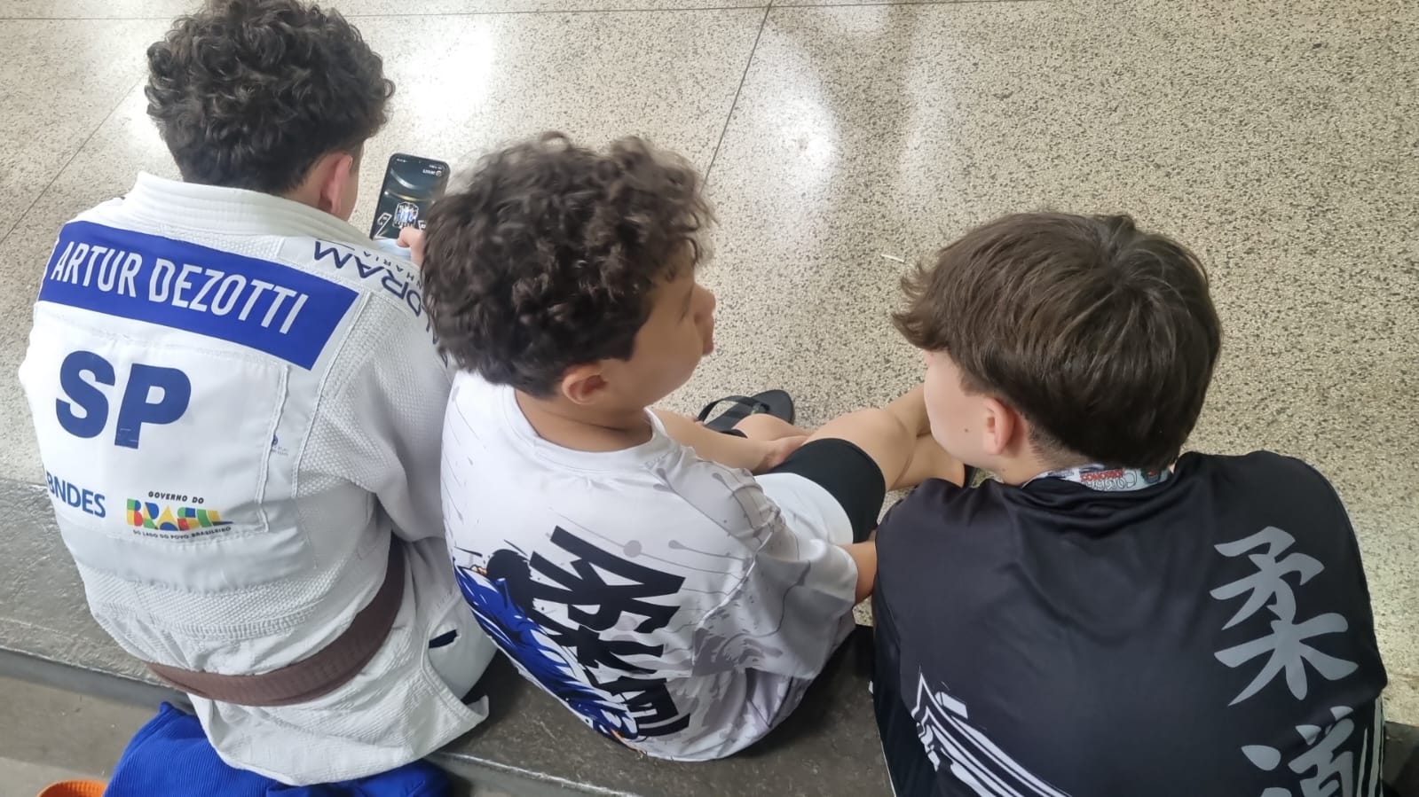 Atletas de outros estados descansando no ginásio ao lado dos atletas Honda ao longo da tarde de treinos