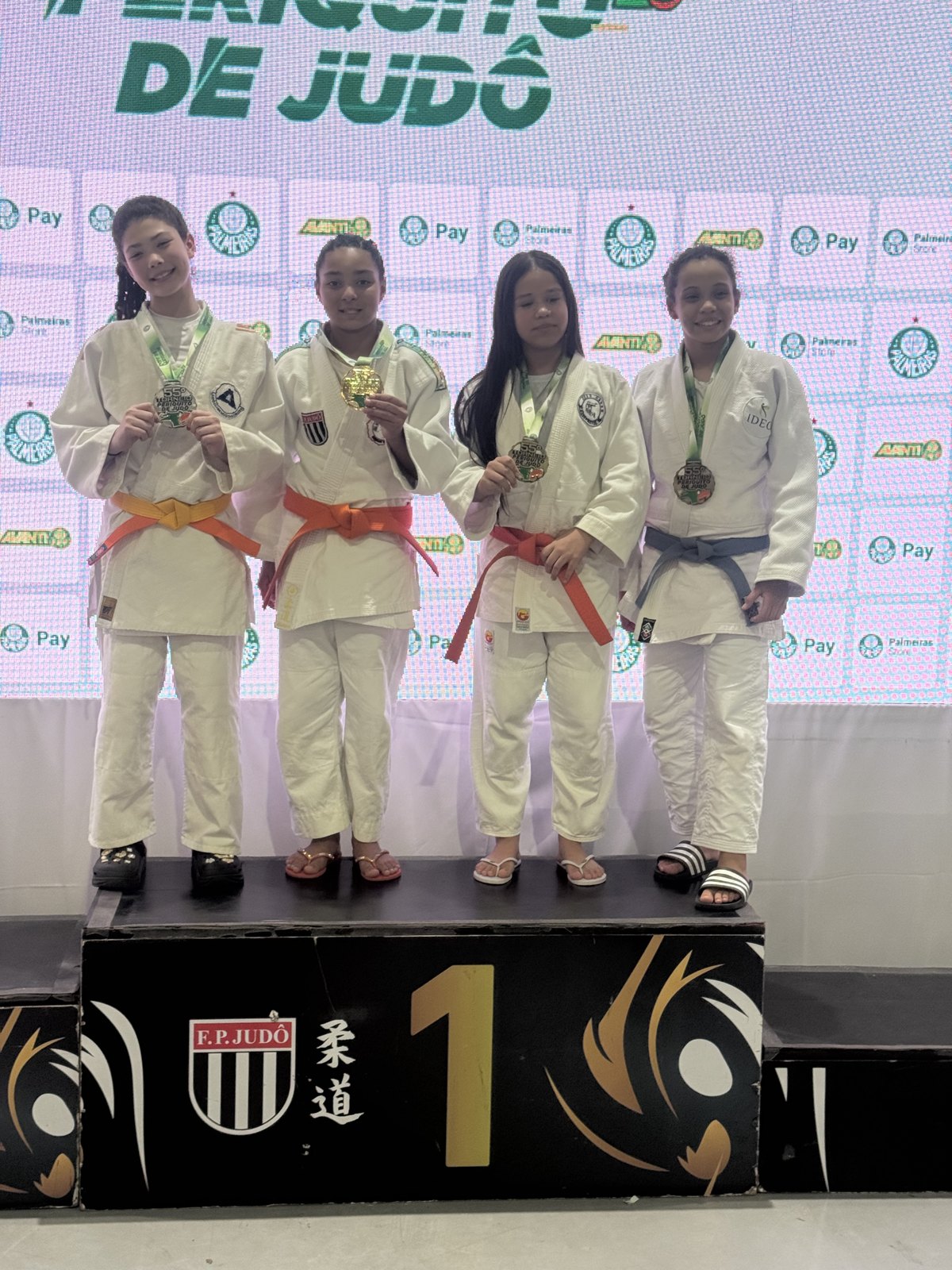 Lídia Sayuri Tsuji Palma no alto do pódio do Sub-13 feminino -48 kg do 55º Torneio Periquito de Judô, com a medalha de ouro