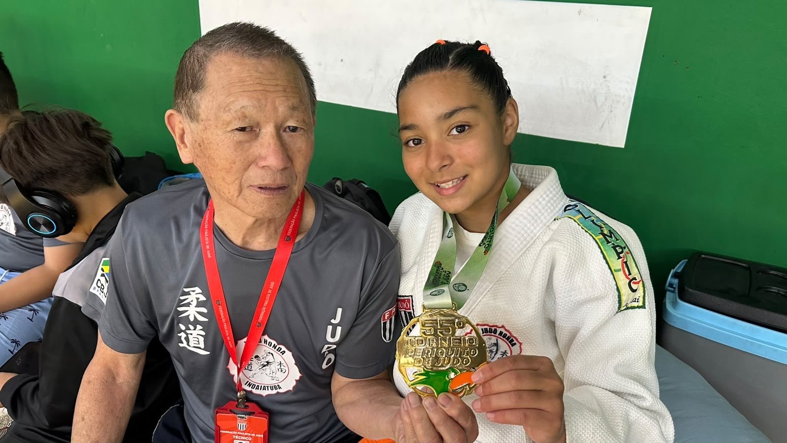 Sensei Sergio Honda ao lado de Lídia Sayuri, que mostra a medalha de ouro do 55º Torneio Periquito de Judô